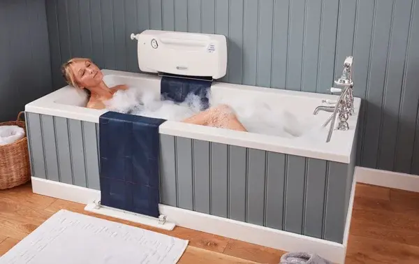 Supplied photograph showing the belt-style bath lift alongside a bath in use